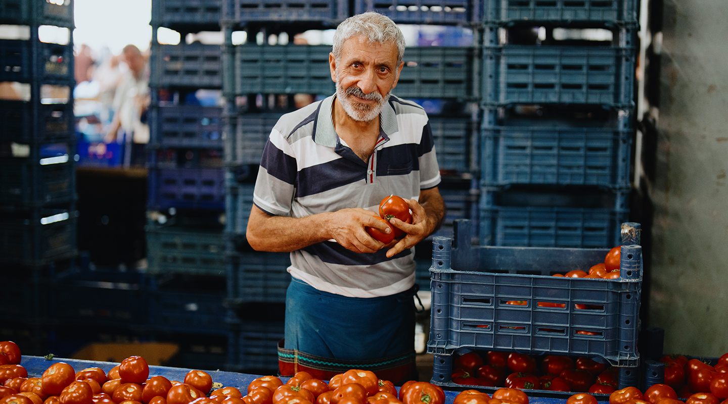 Yayla Foods Men holding tomatoes standing in market